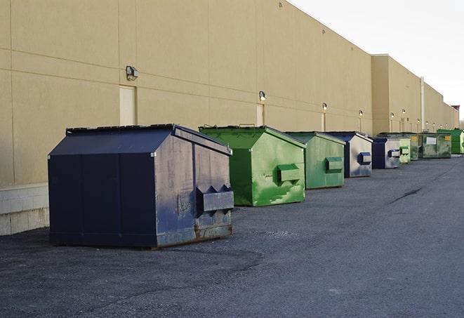 a pile of demolition waste sits beside a dumpster in a parking lot in Covina